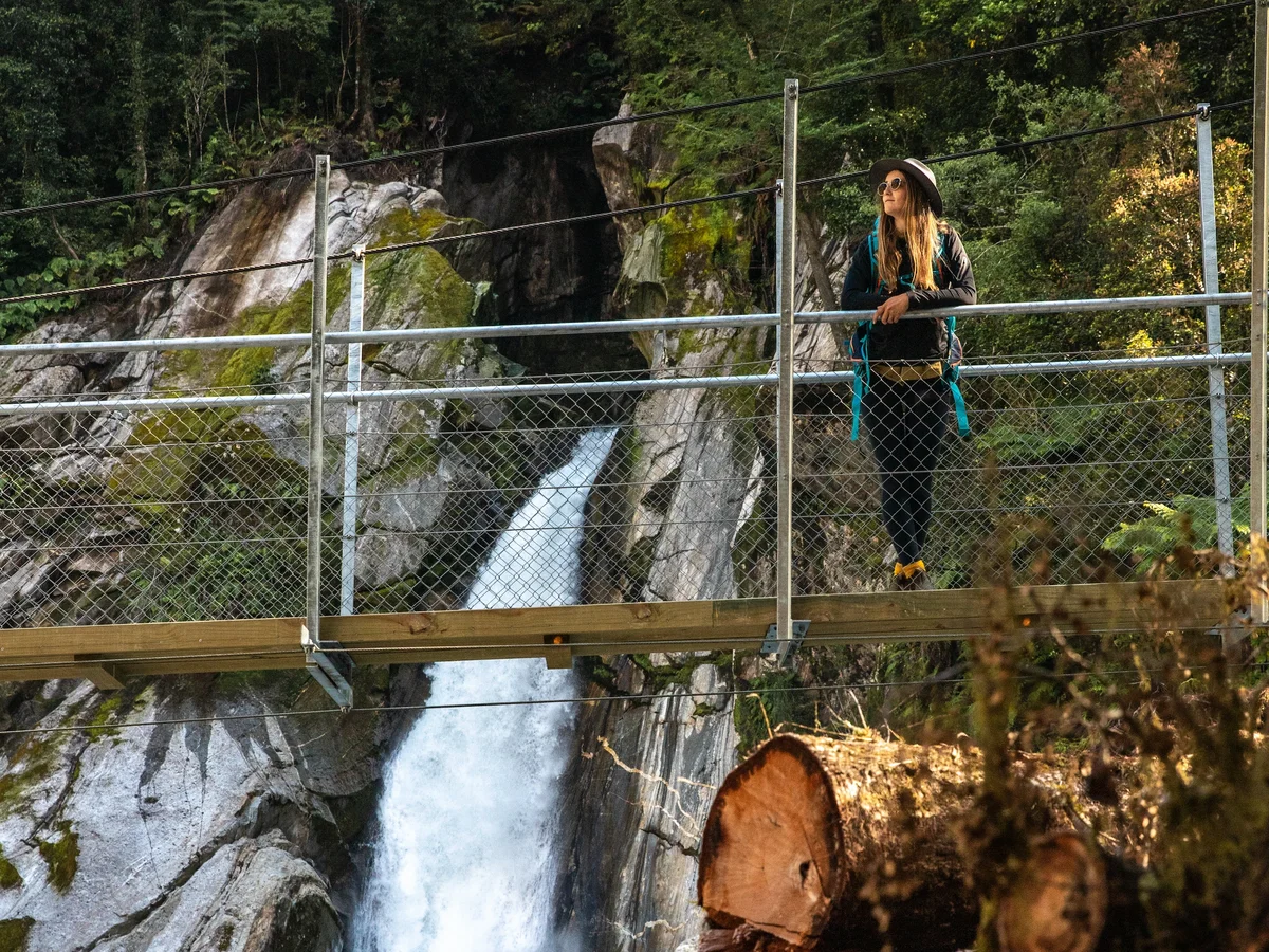 Standing on the bridge at Giant Gates Waterfall, Milford Track Day Hike. Fiordland Outdoors