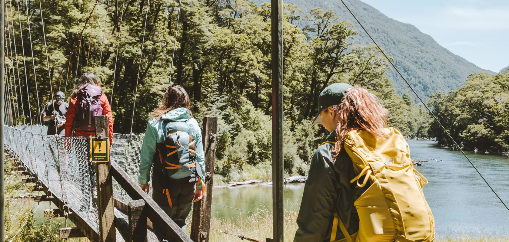 Day walkers heading across the famous Clinton swingbridge on the Milford Track